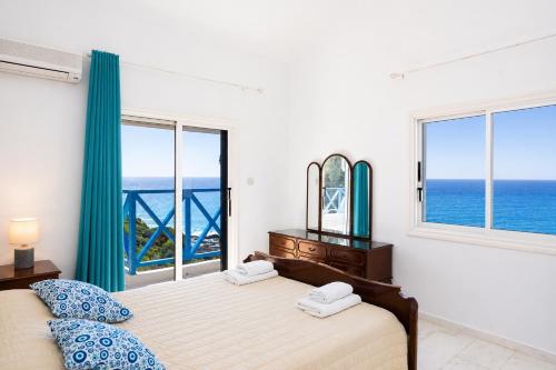 a bedroom with a bed with a view of the ocean at Panorama Villa in Pomos
