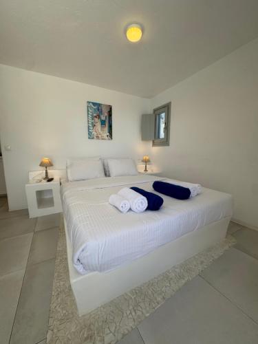 a bedroom with a large white bed with towels on it at Rineia Complex by Live&Travel in Mikonos