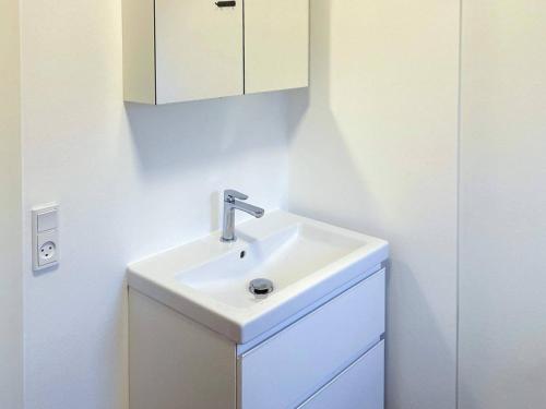 a bathroom with a white sink and a cabinet at Luxury Retreat in Hejlsminde in Hejls