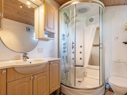 a bathroom with a shower and a sink and a toilet at Charming cottage near forest in Farsø in Farsø