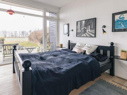 a bedroom with a bed with a blue blanket on it at sunny Cottage with Spa facility in Gedser
