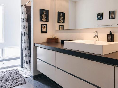 a bathroom with a sink and a mirror at sunny Cottage with Spa facility in Gedser