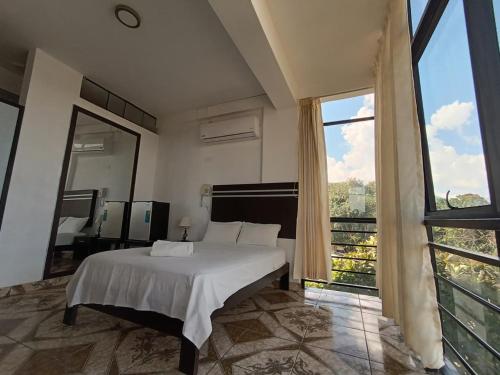 a bedroom with a bed and a large window at Hotel Valle Verde in Tarapoto