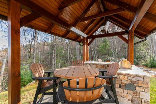 a wooden table and chairs under a wooden pavilion at Bailey's Creek Lodge in Lenoir