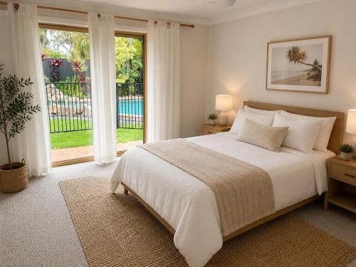 a bedroom with a large bed and a large window at Charming & Spacious 5 Bedroom Bayside House with Pool in Birkdale