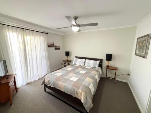 a bedroom with a bed and a ceiling fan at Jubilee Apartment 03 - Bring your own linen in South West Rocks