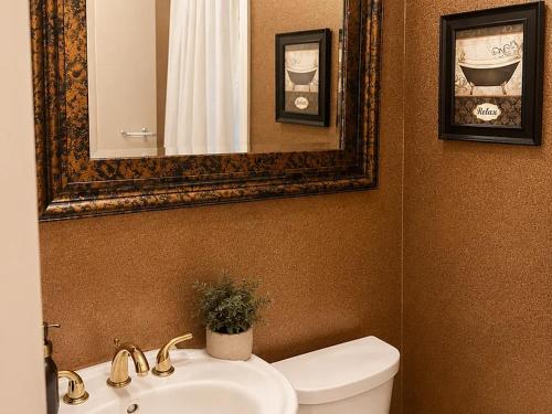 a bathroom with a sink and a toilet and a mirror at Luxury Pre-War Townhouse Bronx 5BR in University Heights