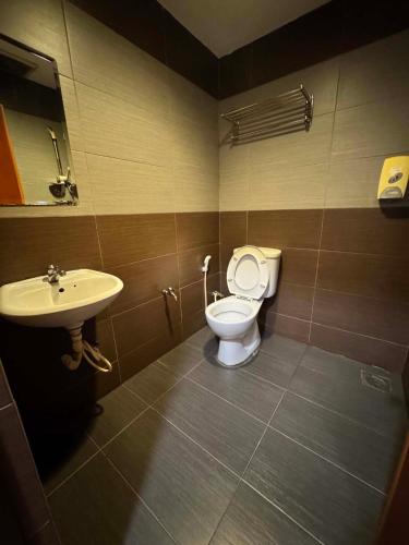 a bathroom with a toilet and a sink at One World Hotel in Kulai