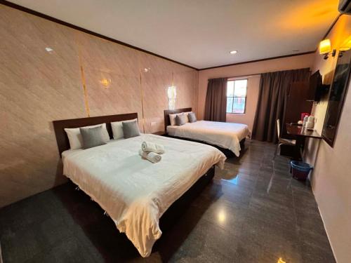 a hotel room with two beds and a television at One World Hotel in Kulai