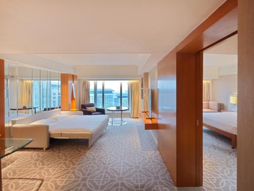 a hotel room with a bed and a living room at Grand Hyatt Beijing in Beijing