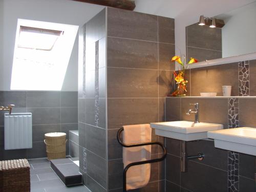 a bathroom with two sinks and a mirror at La Sabotiere in Plumeliau Bieuzy
