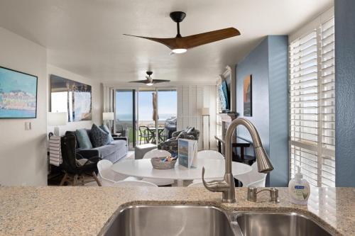 a kitchen with a sink and a living room at D27 - Beachside Bungalow in Oceanside