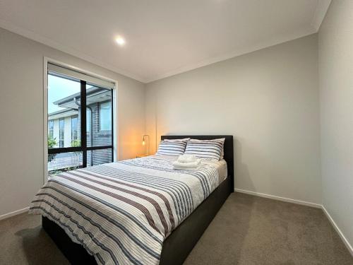a bedroom with a large bed with a window at Sweet Serendipity in Tauranga