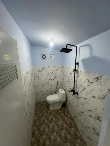 a bathroom with a toilet and a light in it at Tiara Homestay Banyuwangi Near train Station in Banyuwangi
