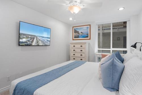 a bedroom with a bed and a tv on the wall at G207 - Surfer's Hideaway in Oceanside