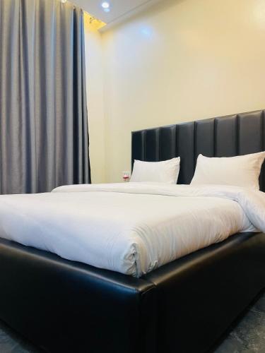 a large bed with white sheets and pillows at KiGALI CLASSIC LODGE in Kigali