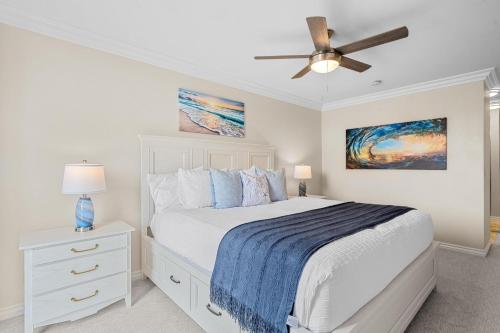 a bedroom with a white bed and a ceiling fan at A217 - Blue Water Escape in Oceanside