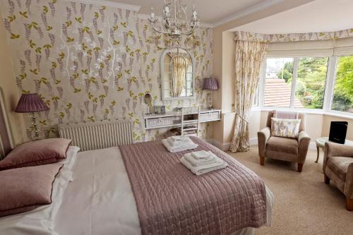 a bedroom with a bed and a chair and a mirror at Fring House Bed and Breakfast in Seaton