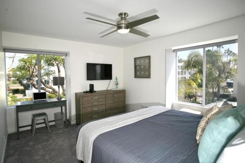 a bedroom with a bed and a desk and a tv at A300 - Pier View Paradise in Oceanside