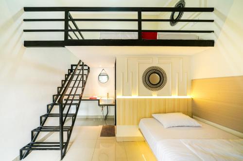 a bedroom with a loft bed and a staircase at JM Tuparev Mitra RedDoorz in Karawang
