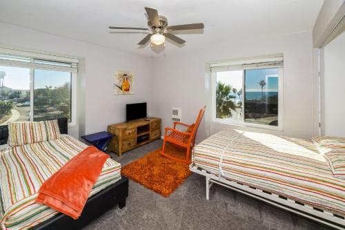 a bedroom with two beds and a ceiling fan at B301 - Seaclusion - On-the-Sand in Oceanside