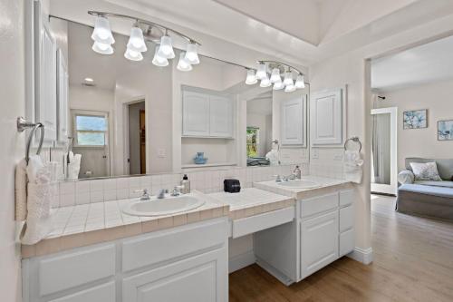 a bathroom with two sinks and a large mirror at Sunset On The Strand in Oceanside