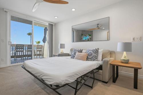 a bedroom with a bed and a couch and a window at D313 - Sea Blue in Oceanside