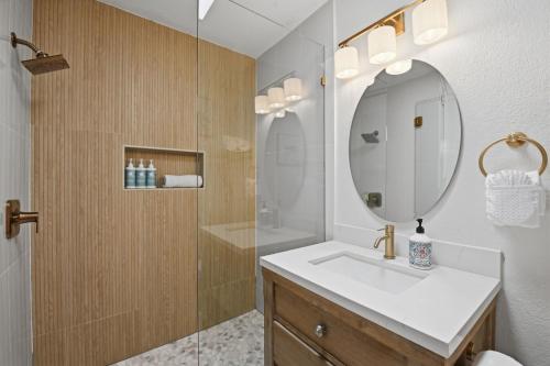 a bathroom with a sink and a shower with a mirror at D313 - Sea Blue in Oceanside