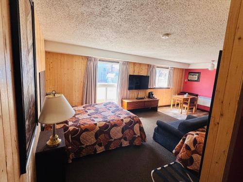 a hotel room with a bed and a couch at Wheel Inn Motel in Assiniboia