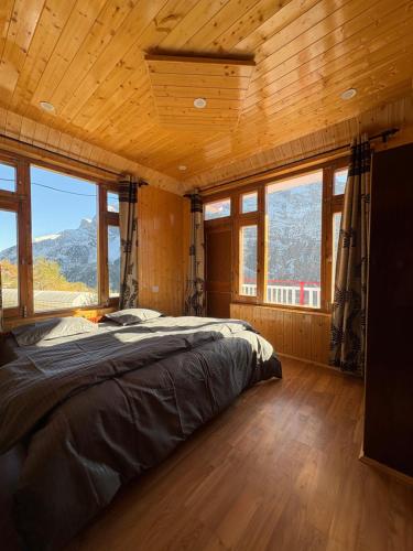 a bedroom with a bed in a room with windows at Shubham homestay in Sissu