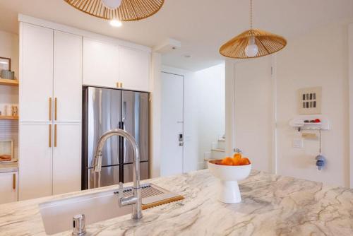 a kitchen with a sink and a bowl of oranges on a counter at B304 - The Lookout in Oceanside