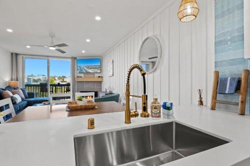 a kitchen with a stainless steel sink and a living room at B302 - Barefoot Villa in Oceanside