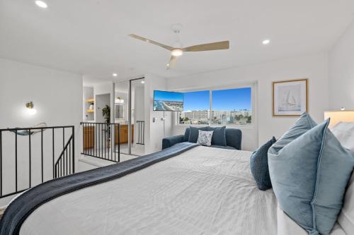 a bedroom with a large bed with blue pillows at B302 - Barefoot Villa in Oceanside