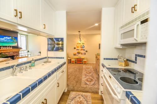 a kitchen with white cabinets and a sink and a stove at C4 - Coastal Cottage in Oceanside