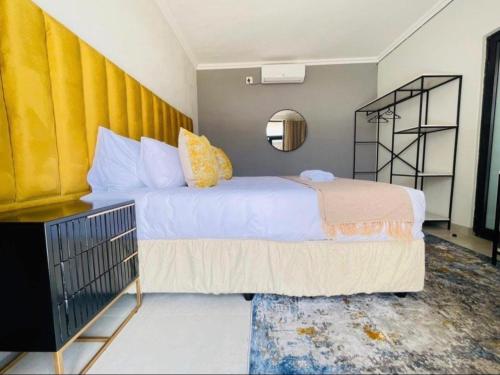 a bedroom with a large bed and a mirror at MRF Lodge in Louis Trichardt