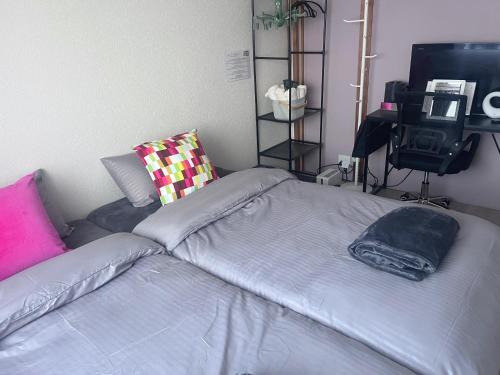 a bedroom with a bed and a tv in it at Cafe Sharehouse Kokoro Nest Kyoto in Kyoto