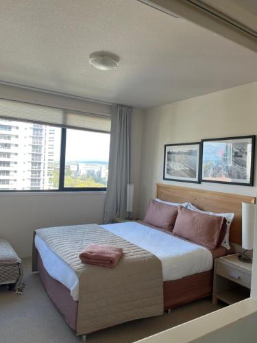 a bedroom with a large bed with a large window at Broadbeach on the Park in Gold Coast