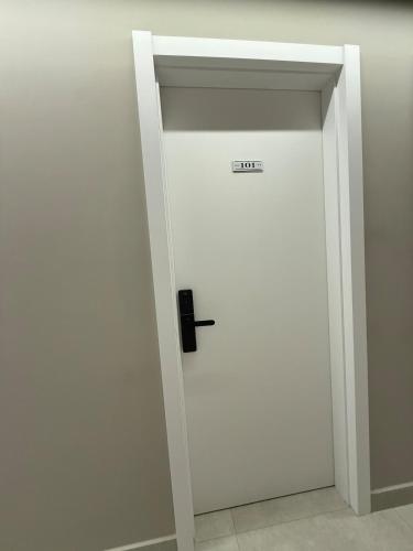 a white door with a sign on it in a room at Suite Boutique 101 Cheia de Graca in Divinópolis