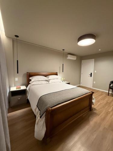 a bedroom with a large bed in a room at Suite Boutique 101 Cheia de Graca in Divinópolis