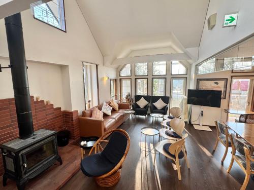 a living room with a couch and a fireplace at Pension Lavender in Furano