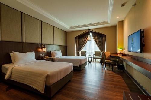 a hotel room with two beds and a desk at Al Meroz Hotel Bangkok - The Leading Halal Hotel in Bangkok