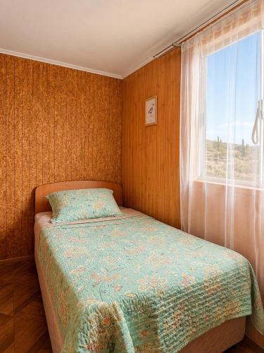 a small bedroom with a bed and a window at Viento Sur Astro Camping & Cabañas in Los Hornitos