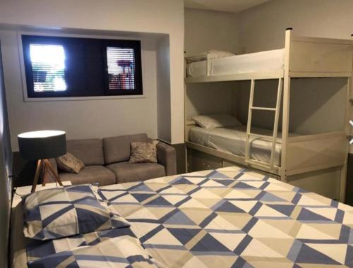 a bedroom with a bunk bed and a couch at iHostel Aldeota in Fortaleza