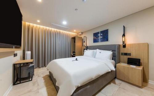 a bedroom with a large bed and a flat screen tv at Daejeon Continew Hotel in Daejeon