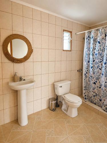 a bathroom with a toilet and a sink and a mirror at Viento Sur Astro Camping & Cabañas in Los Hornitos