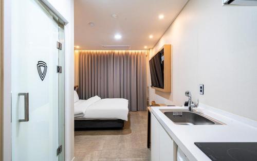 a bathroom with a sink and a bed in a room at Daejeon Continew Hotel in Daejeon