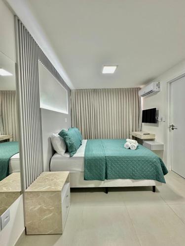 a bedroom with a bed with a green bedspread at Compacto Flat na Orla de Intermares in Cabedelo