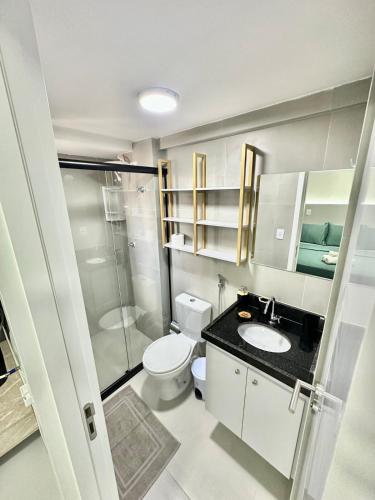 a bathroom with a toilet and a sink and a shower at Compacto Flat na Orla de Intermares in Cabedelo