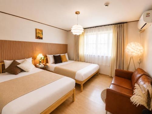 a hotel room with two beds and a couch at 수원 화서역 편한 집 in Suwon