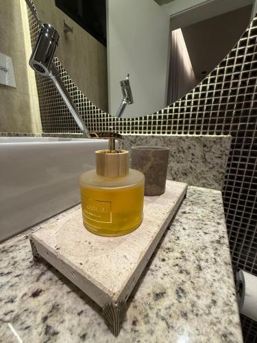 a yellow container sitting on a counter in a bathroom at Suite Boutique 102 Cheia de Graça in Divinópolis